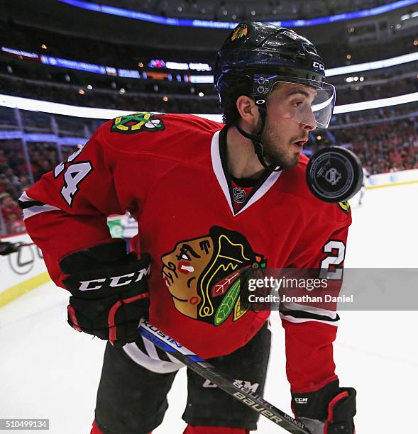 The puck flies past the face of Phillip Danault of the Chicago Blackhawks during a game against the Toronto Maple Leafs at the United Center on...