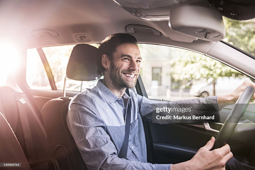 Confident businessman driving his car.