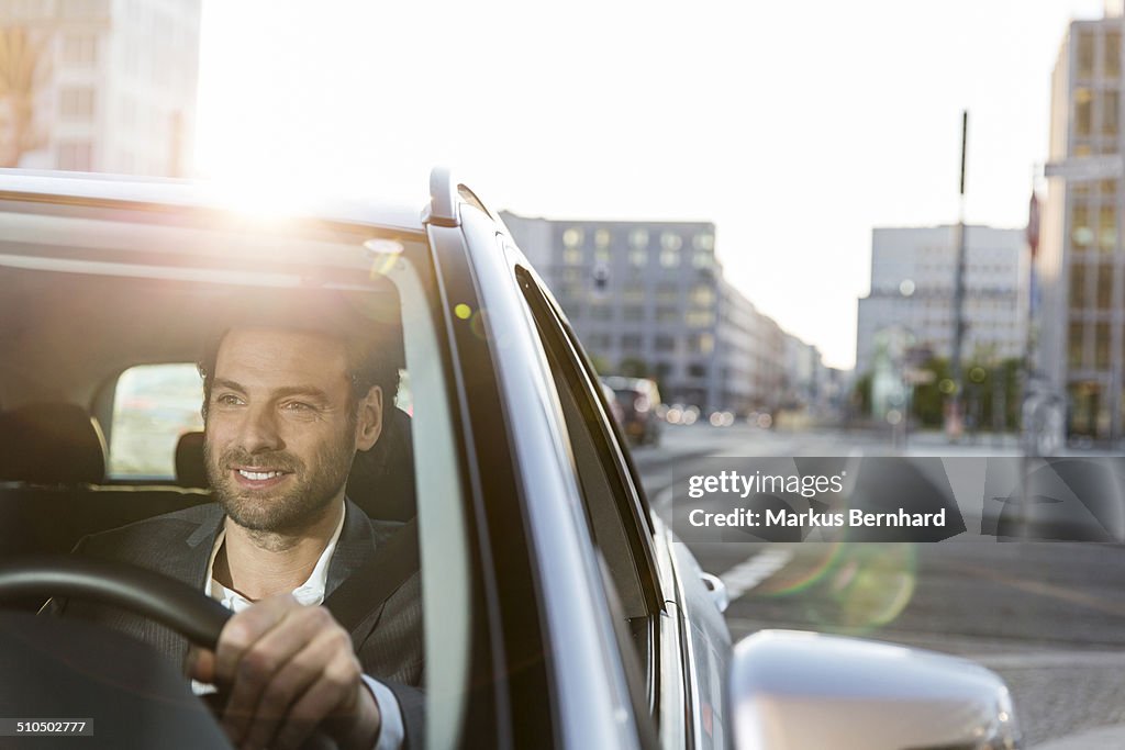 Businessman driving car in the city.