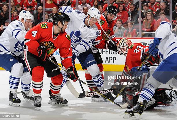 Leo Komarov and Peter Holland of the Toronto Maple Leafs battle for the puck with Niklas Hjalmarsson and Michal Rozsival of the Chicago Blackhawks,...