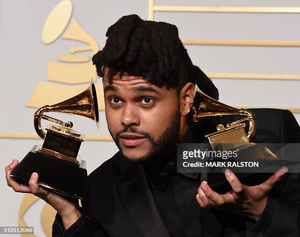 The Weeknd holds his trophies for Best R&B Performance and Best Urban Contemporary Album in the press room during the 58th Annual Grammy Music Awards...