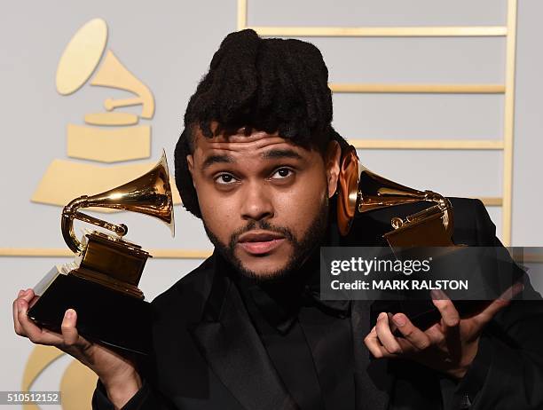 The Weeknd holds his trophies for Best R&B Performance and Best Urban Contemporary Album in the press room during the 58th Annual Grammy Music Awards...