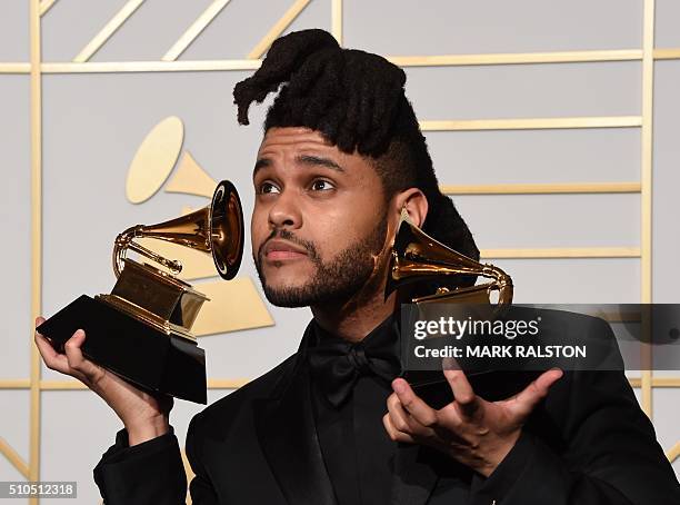 The Weeknd holds his trophies for Best R&B Performance and Best Urban Contemporary Album in the press room during the 58th Annual Grammy Music Awards...