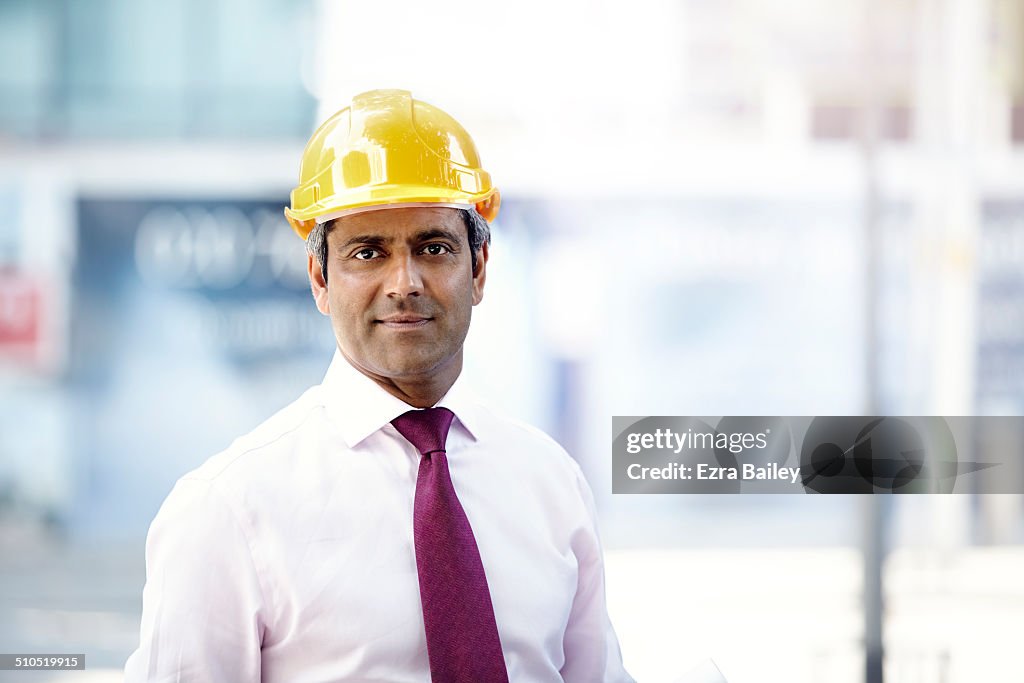 A portrait of a businessman in a hard hat.