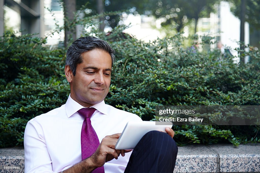 Businessman using digital tablet and relaxing.