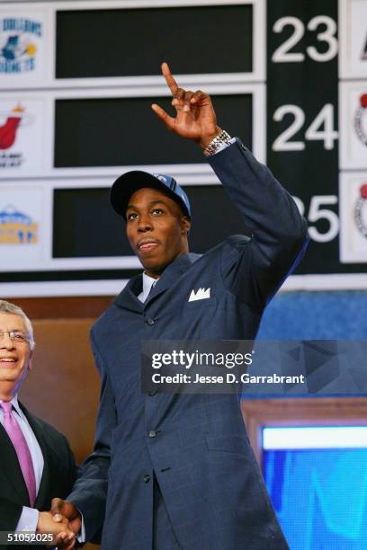 Dwight Howard acknowledges the fans as he shakes hands with NBA Commissioner David Stern during the 2004 NBA Draft on June 24, 2004 at the Theater at...