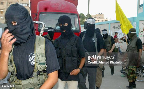 Masked gunmen from the al-Aqsa Martyrs Brigade of the Fatah Movement parade through the streets on July 12, 2004 in the Zeitoun district of Gaza...