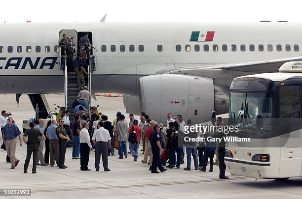 Group of 130 Mexican nationals who entered the U.S illegally are shown boarding a special Mexicana Aviation charter flight to Mexico City, the first...