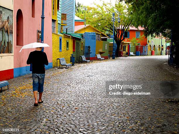 man walking under the rain - caminito buenos aires stock pictures, royalty-free photos & images