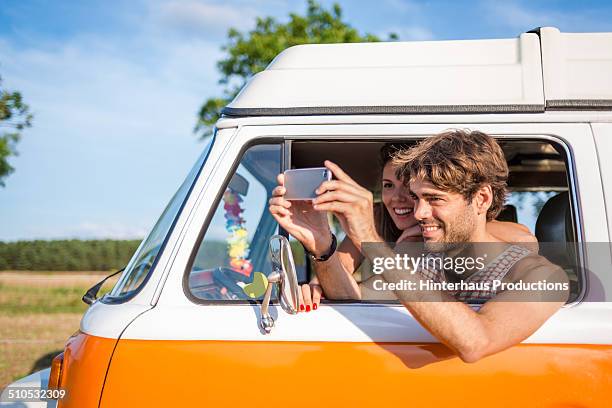 young couple in camper taking pictures - young men camping stock pictures, royalty-free photos & images