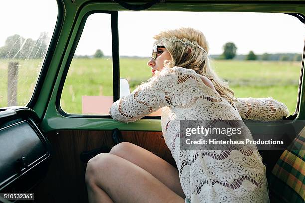 hippie woman driving in old bus - boho-stil stock-fotos und bilder
