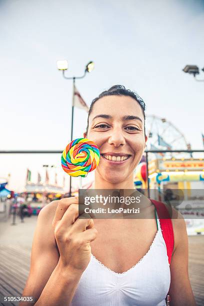 woman with lollipop at amusement park - luna park stock pictures, royalty-free photos & images