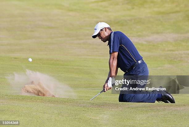 Michael Campbell of New Zealand plays out of a bunker whilst kneeling during practice for the 133rd Open Championship at the Royal Troon Golf Club on...