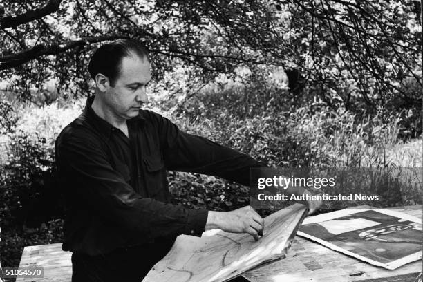 American painter Will Barnet makes a sketch under the shade of a tree, 1942.