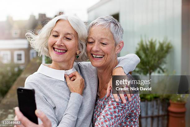 freinds taking a selfie with mobile phone - gray hair stock pictures, royalty-free photos & images