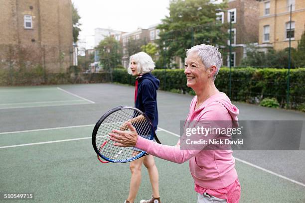 friends playing tennis - mature women friends stock pictures, royalty-free photos & images