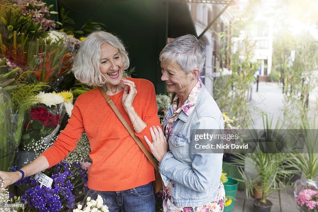 Friends choosing flowers at a market stall