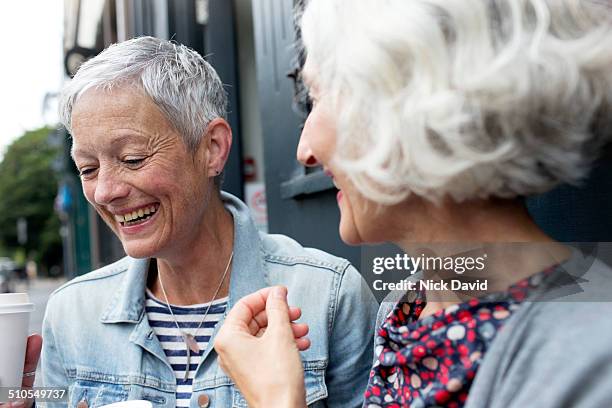 friends chatting outside a cafe - mature women cafe stock pictures, royalty-free photos & images