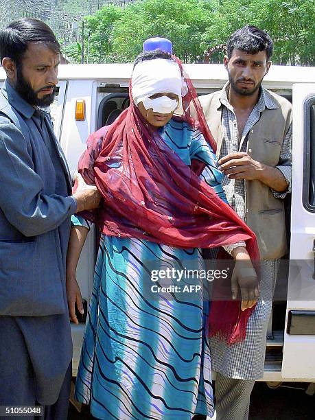 Indian Kashmiri woman Mariam Begum her face heavily bandaged after being mutilated by alleged militants, is helped out of an ambulance in Chandakode...