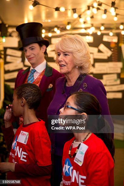 Camilla, Duchess of Cornwall speaks to children attending the 'Imagine' festival as actor Jonothan Slinger as 'Willy Wonka' looks on during a preview...