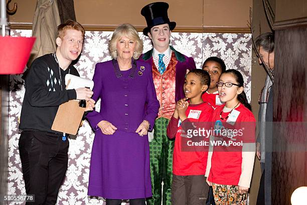 Camilla, Duchess of Cornwall walks with children attending the 'Imagine' festival as actor Jonothan Slinger as 'Willy Wonka' looks on during a...