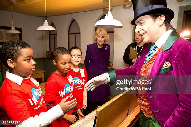 Actor Jonothan Slinger as 'Willy Wonka' greets children as Camilla, Duchess of Cornwall looks on during a preview of the new 'Wondercrump World of...
