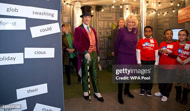 Camilla, Duchess of Cornwall speaks to children attending the 'Imagine' festival as actor Jonothan Slinger as 'Willy Wonka' looks on during a preview...