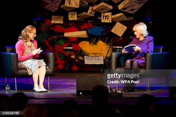Camilla, Duchess of Cornwall reads as Charlotte Scott, 'Miss Honey' from the Royal Shakespeare Company's production of 'Matilda The Musical, sits...