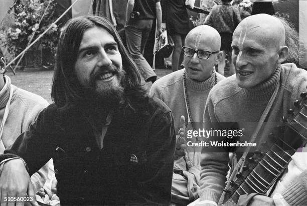 English musician, singer and songwriter, George Harrison sits with members of the Hare Krishna movement, 28th August 1969.