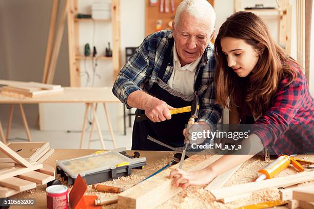 mädchen mit opa im workshop - ausbildung und tischler stock-fotos und bilder