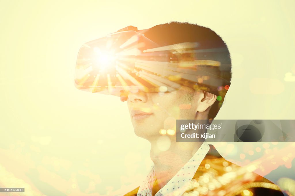 Double exposure of man wearing virtual reality headset