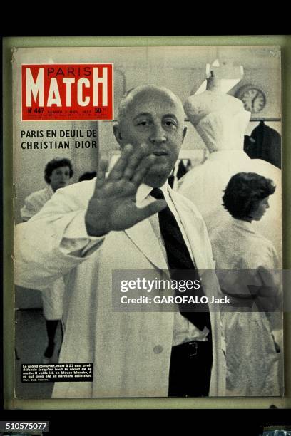 The cover of 'Paris Match' magazine no.447, 2nd November 1957 : Christian Dior, his hand toward the camera, wearing a white coat and surrounded by...