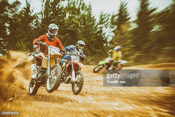 motocross bikers on a dirt road - motorcross stock pictures, royalty-free photos & images