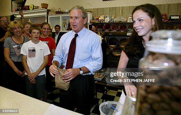 President George W. Bush buys a bag of bear claws as he does an impromptu stop on his Bus trip along with his daughter Barbara at the Mick's Candyman...