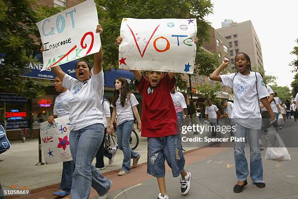 Children hold signs while marching with hundreds of other children and teens from New York and Philadelphia July 14, 2004 in New York City to...