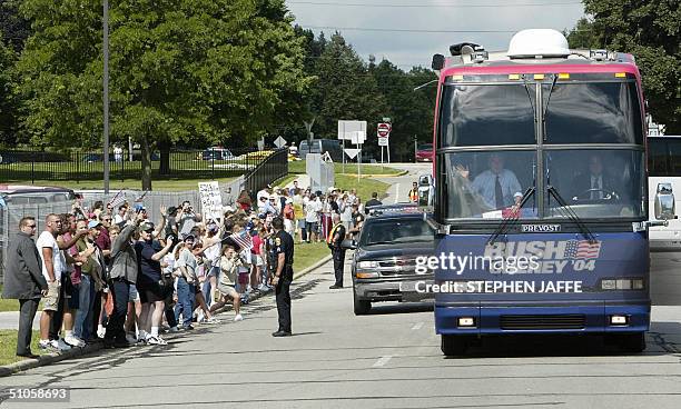President George W. Bush waves to supporters along the road as he kicks off a one-day bus trip through Wisconsin 14 July, 2004. Bush has been...