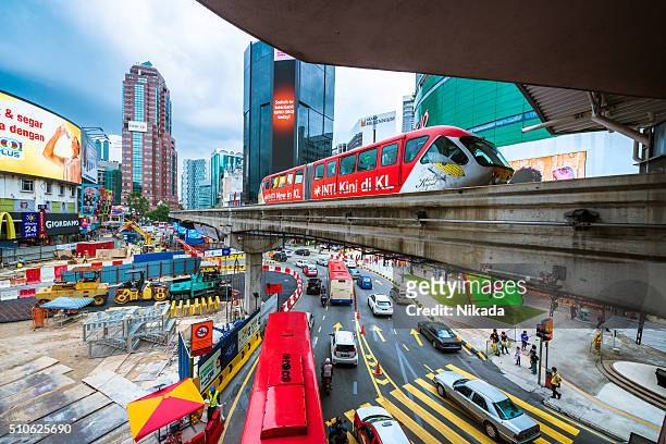 downtown kuala lumpur with road, train, billboards and cars - kuala lumpur stock pictures, royalty-free photos & images
