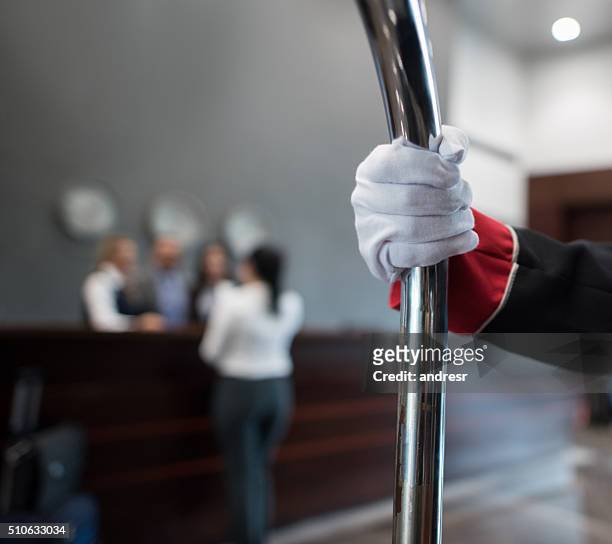 bellboy carrying bags at the hotel - piccolo stockfoto's en -beelden
