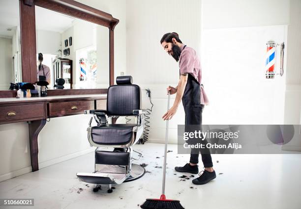 male barber sweeping floor - interieur salon stock pictures, royalty-free photos & images