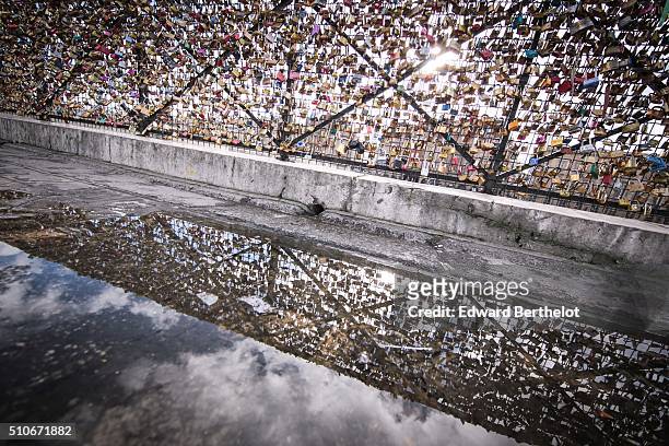 Love locks reflecting into a water puddle, on Pont Neuf, on February 7, 2016 in Paris, France.