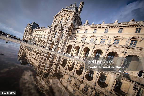 The Louvre Palace reflecting into a water puddle, on February 7, 2016 in the 1st quarter of Paris, France.