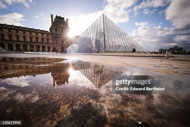 The Louvre Pyramid reflecting into a water puddle, on February 7, 2016 in the 1st quarter of Paris, France.