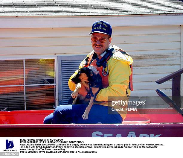 1292Nc-092299-Dscn073 Princeville, Nc 9/22/99 Coast Guard Chief Scott Pettis Comforts This Puppy Which Was Found Floating On A Debris Pile In...