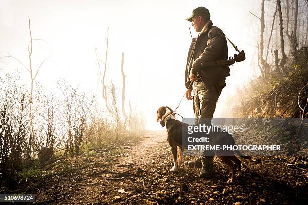 jäger und sein hund im wald - hunting stock-fotos und bilder