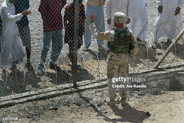 Army guard communicates with prisoners that are housed in tents in the Abu Ghraib prison, on July 15, 2004 west of Baghdad, Iraq. Many of the...