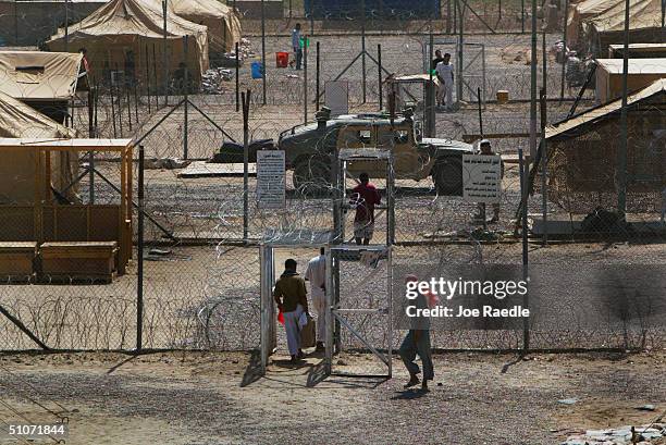 Prisoners mill around in a common area where they are housed in tents, in the Abu Ghraib prison on July 15, 2004 west of Baghdad, Iraq. Many of the...