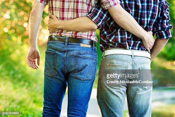 zwei männer gehen mit den armen um die taille - buttocks gay stock-fotos und bilder