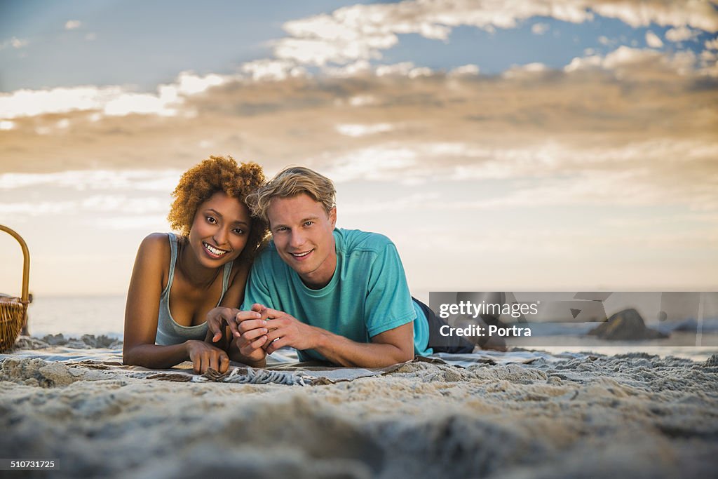 Happy couple lying down on beach