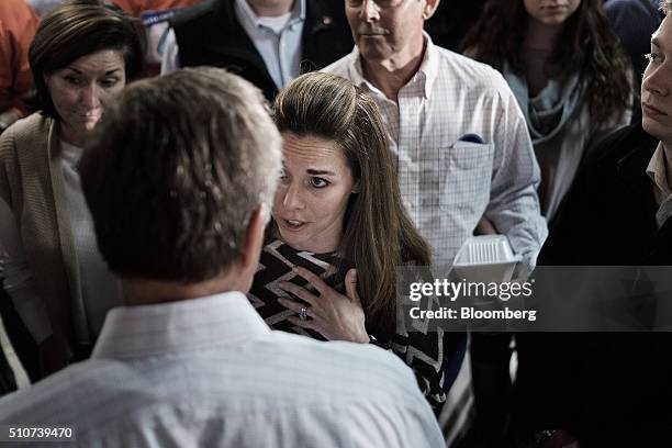 An attendee speaks with John Kasich, governor of Ohio and 2016 Republican presidential candidate, during a town hall event at Murray's Neighborhood...