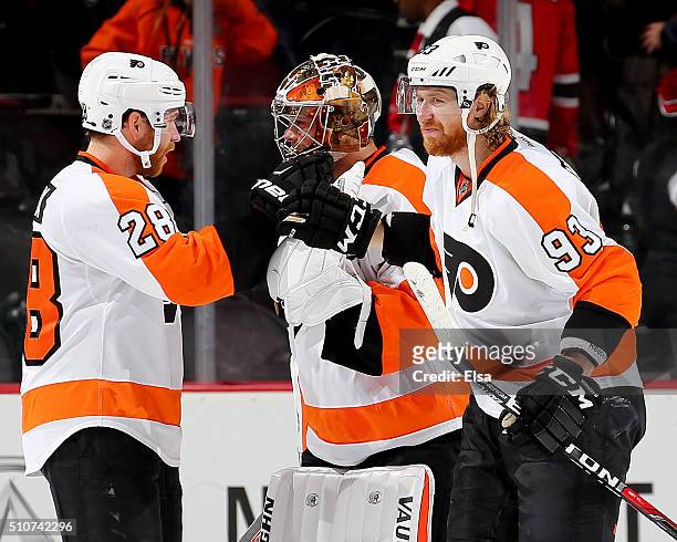 Claude Giroux and Jakub Voracek of the Philadelphia Flyers congratulate Michal Neuvirth after the win over the New Jersey Devils on February 16, 2016...